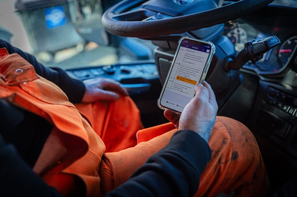 Chauffeur bekijkt de opdrachten van vandaag in de Peanuts-app in de cabine